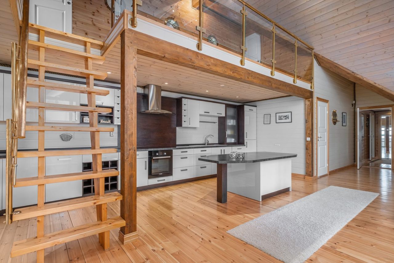 Atlantic Grand — kitchen island and brass-railed mezzanine staircase