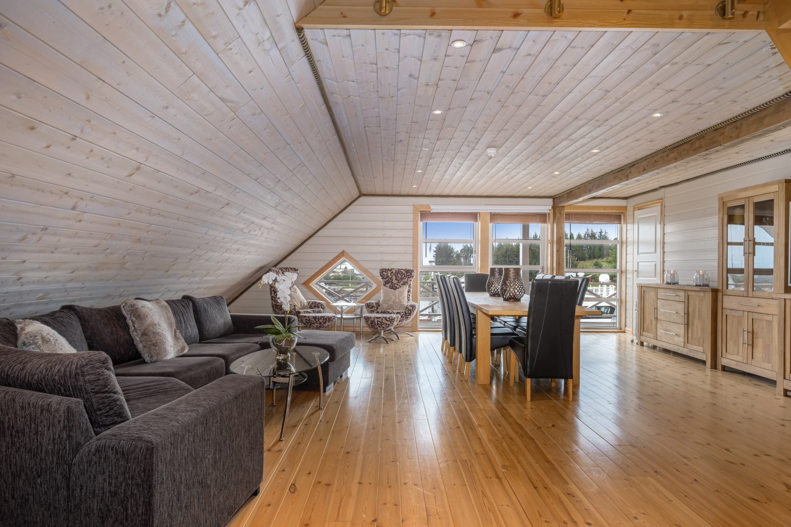 Atlantic Grand — wide open living area with dark corner sofa and dining beyond