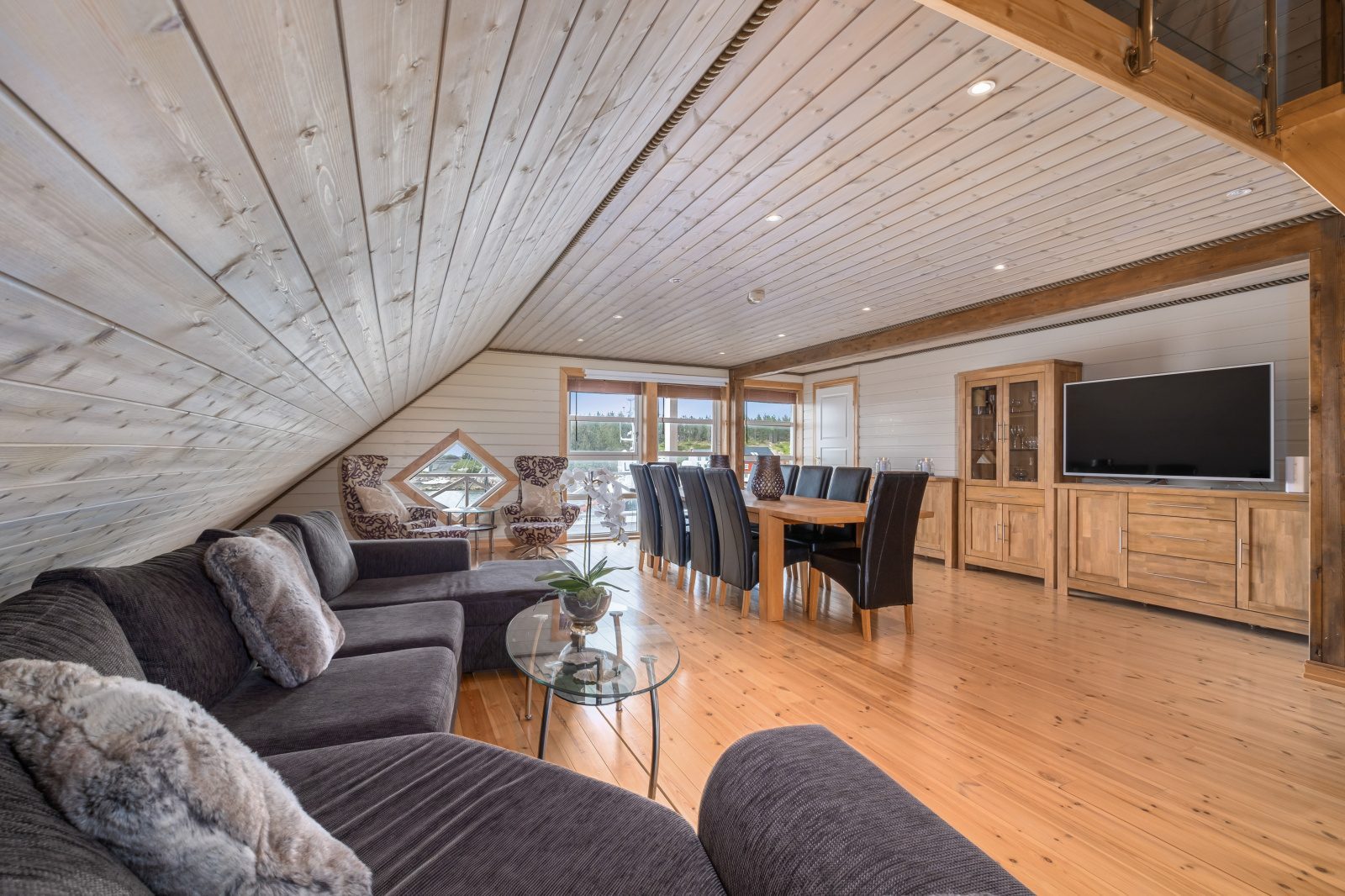 Atlantic Grand — open living with dark sofa, flat-screen TV and diamond window