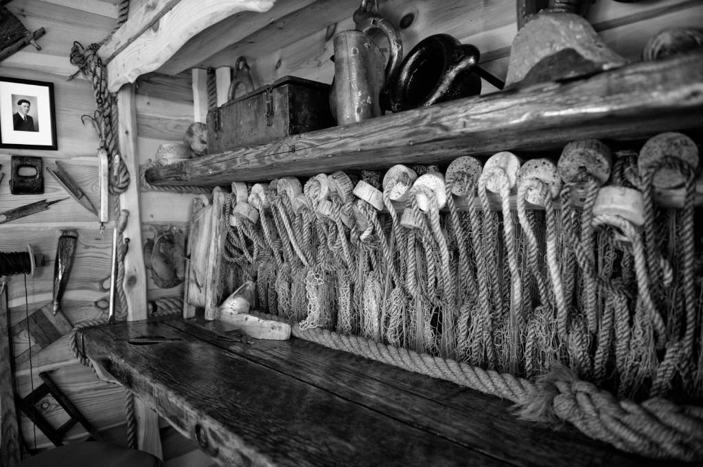 Rows of old fishing ropes and nets arranged on a wooden shelf inside the museum