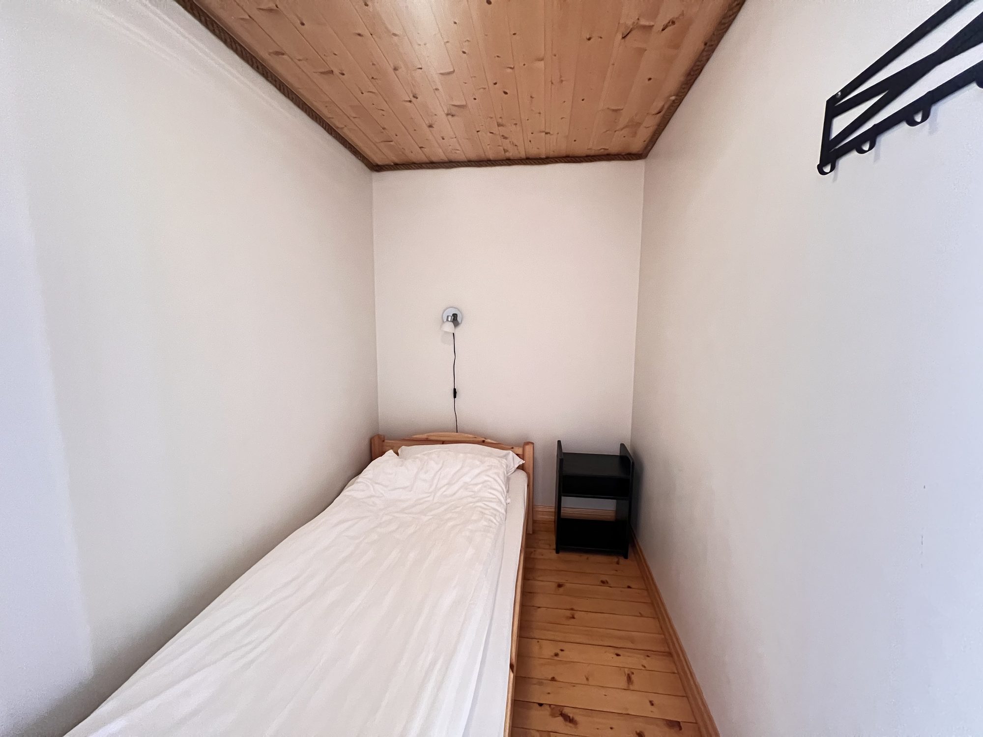 The Heritage — single bedroom with wooden bed frame and bedside table
