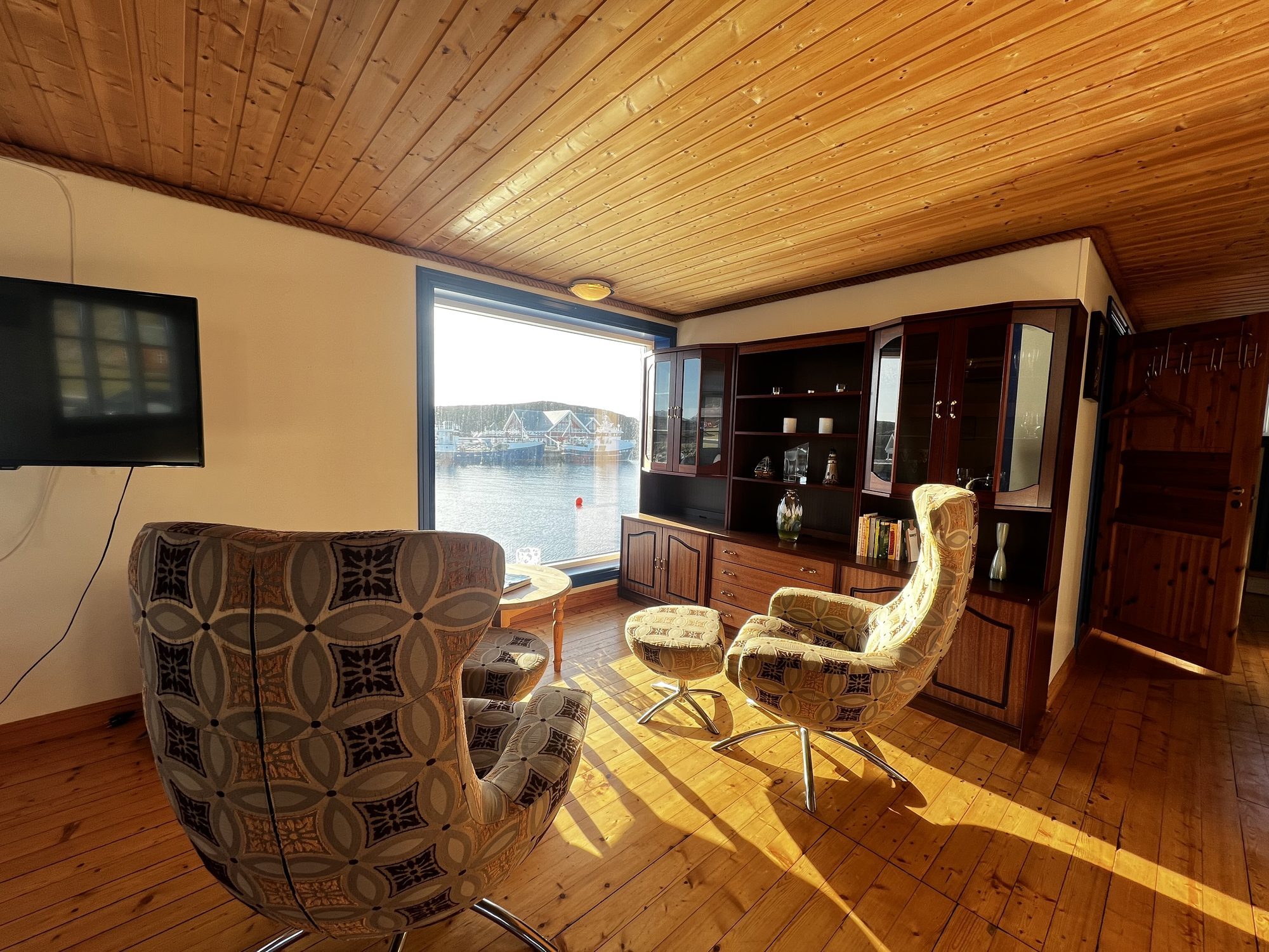 The Heritage — retro lounge chairs facing the harbour through a large blue-framed window