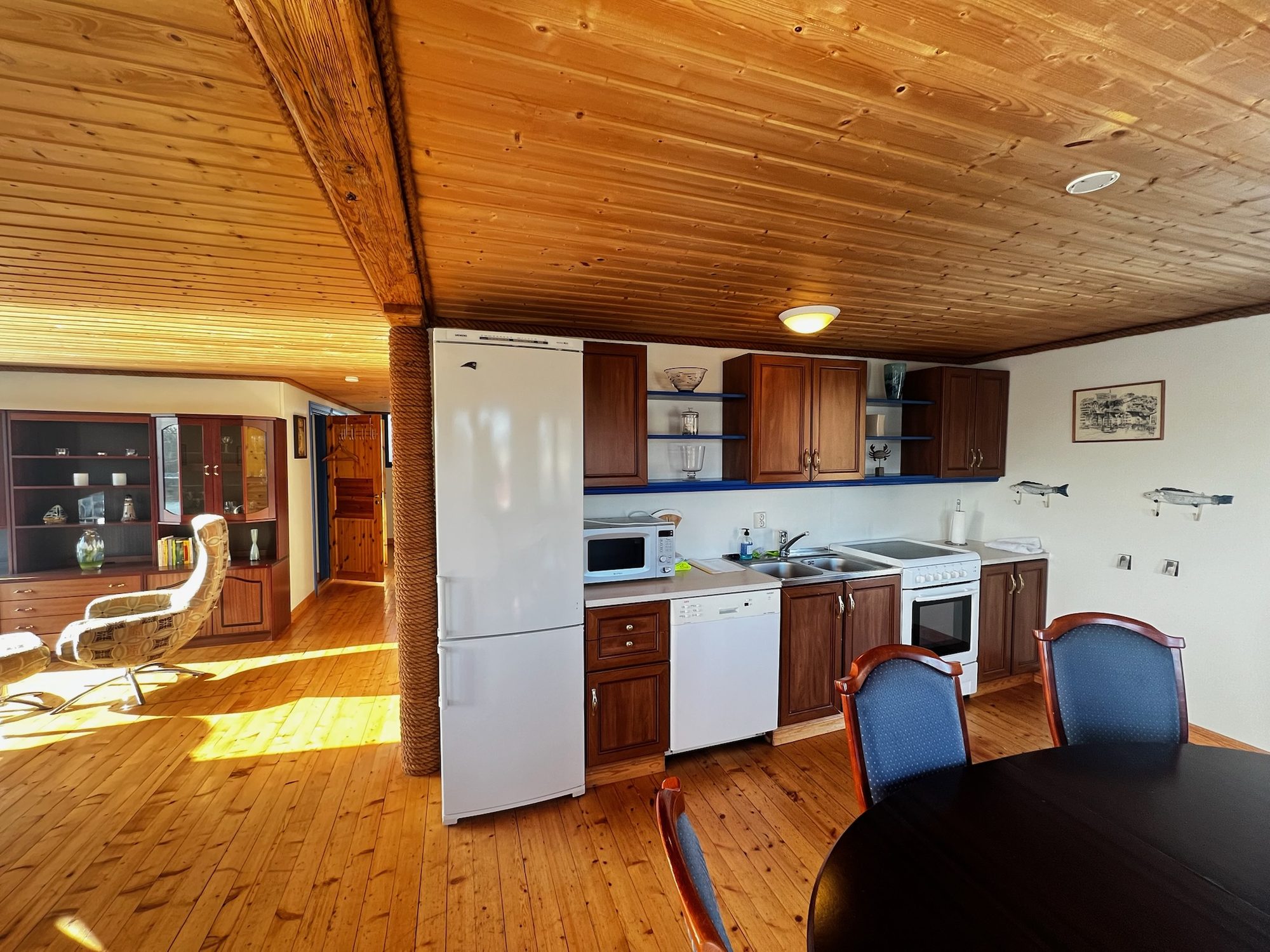 The Heritage — kitchen with dark wood cabinets, fridge and dining table