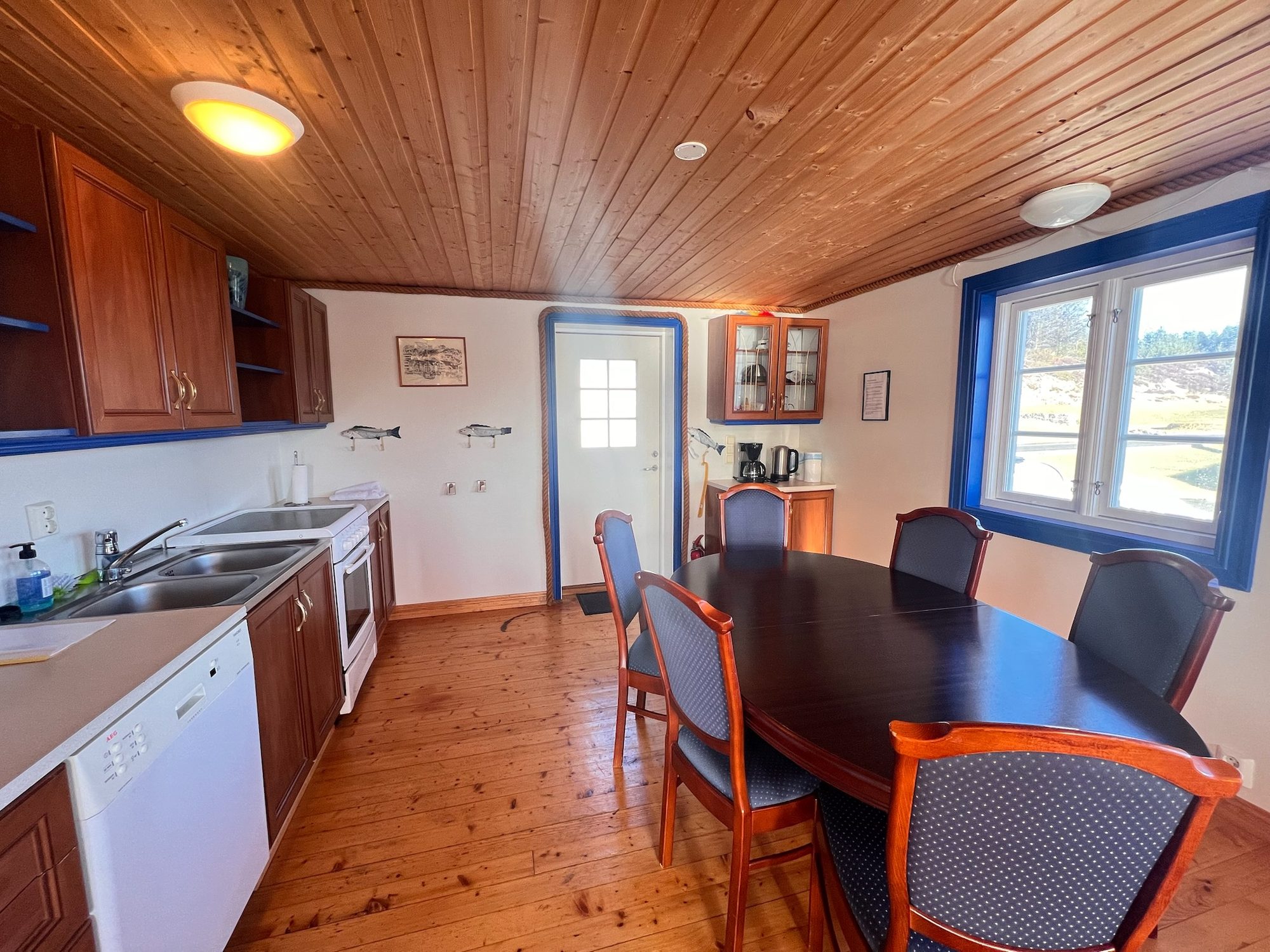 The Heritage — round dining table with blue-framed chairs and a blue-framed window
