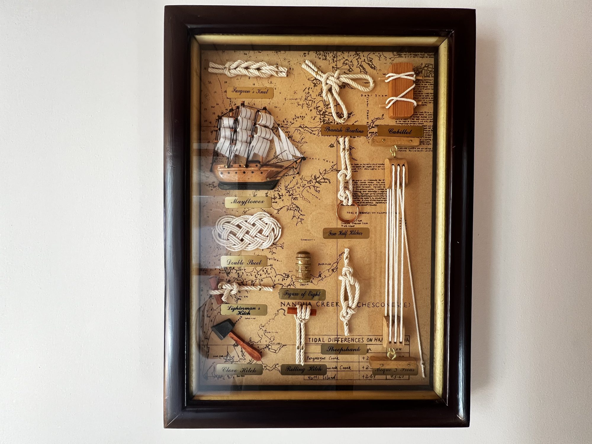 The Heritage — framed display of nautical knots and a model sailing ship