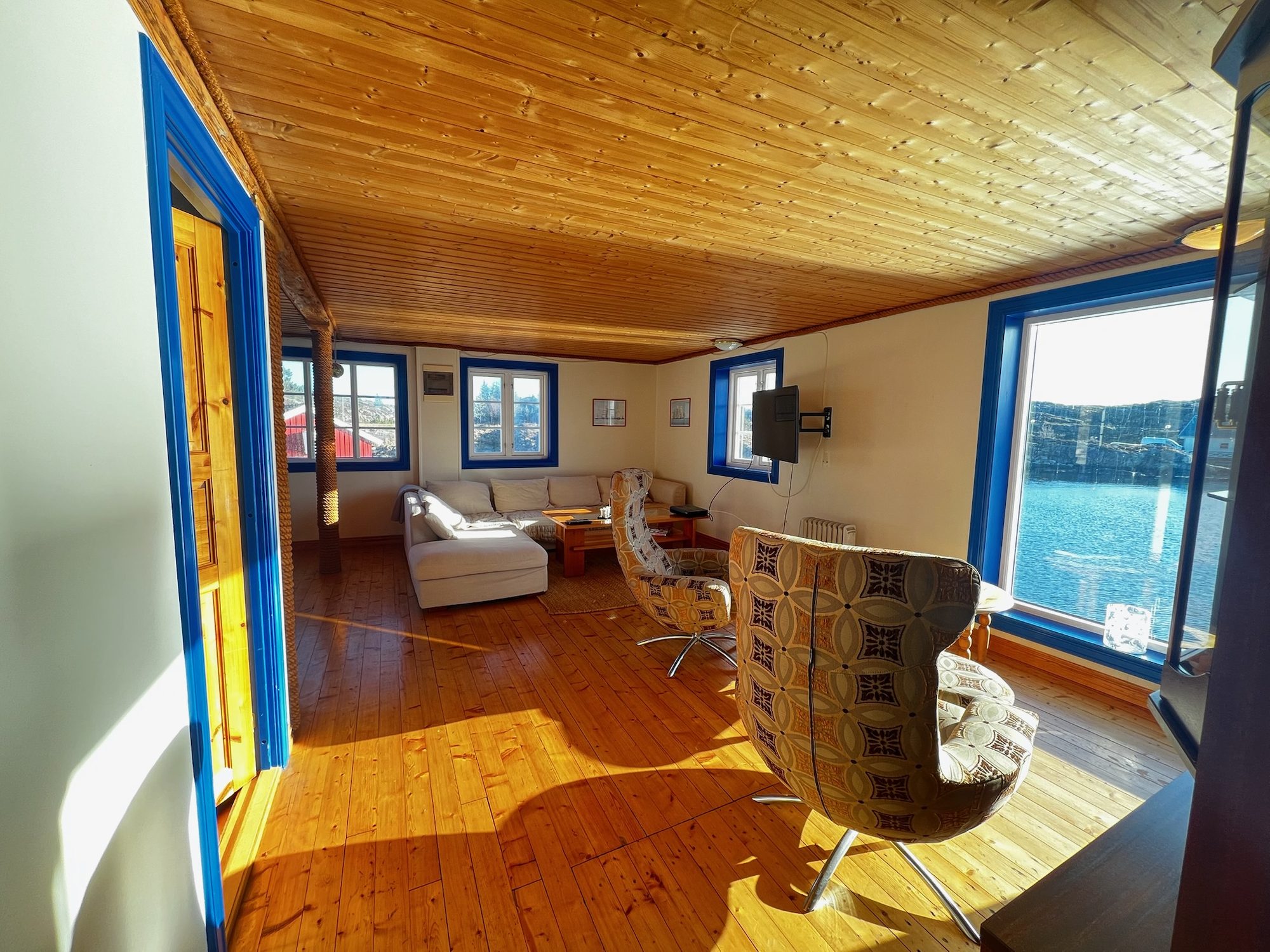 The Heritage — living room seen from the entrance, sofa and swivel chairs facing the water