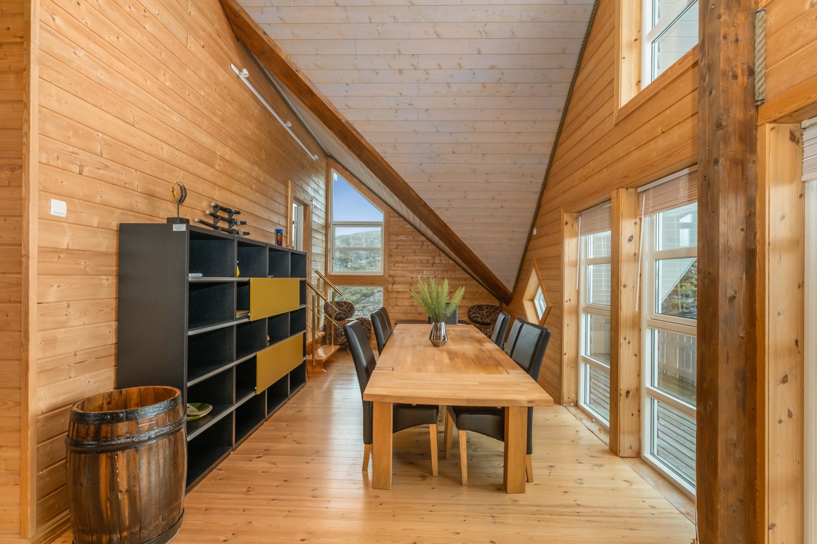 Sea View — upper-floor dining table with shelving and sea-view windows