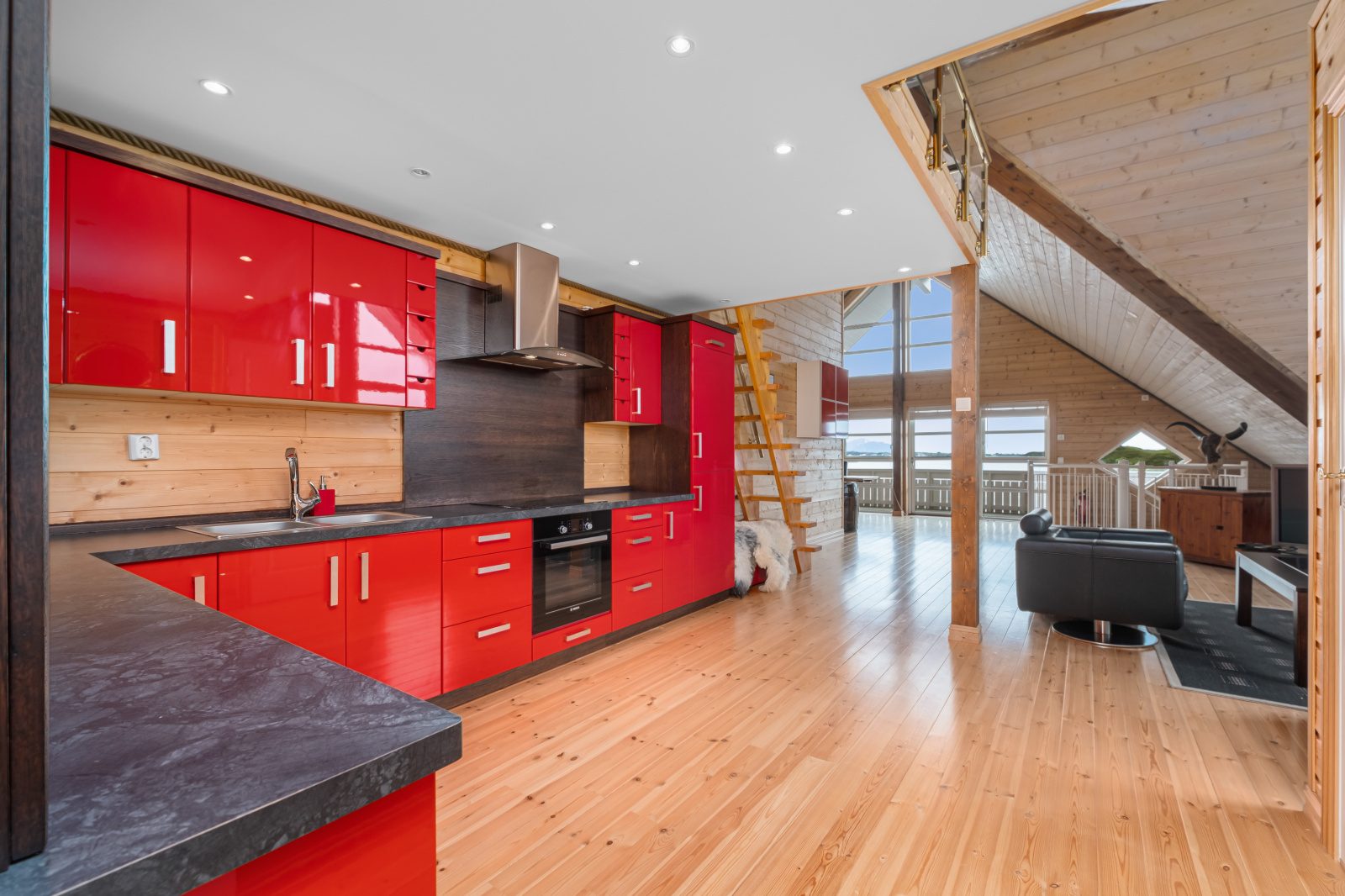 Sea View — red kitchen with open-plan living and mezzanine staircase