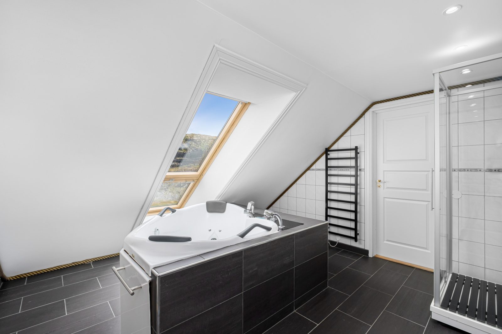 Aurora Suite — bathroom with corner jacuzzi bath and skylight