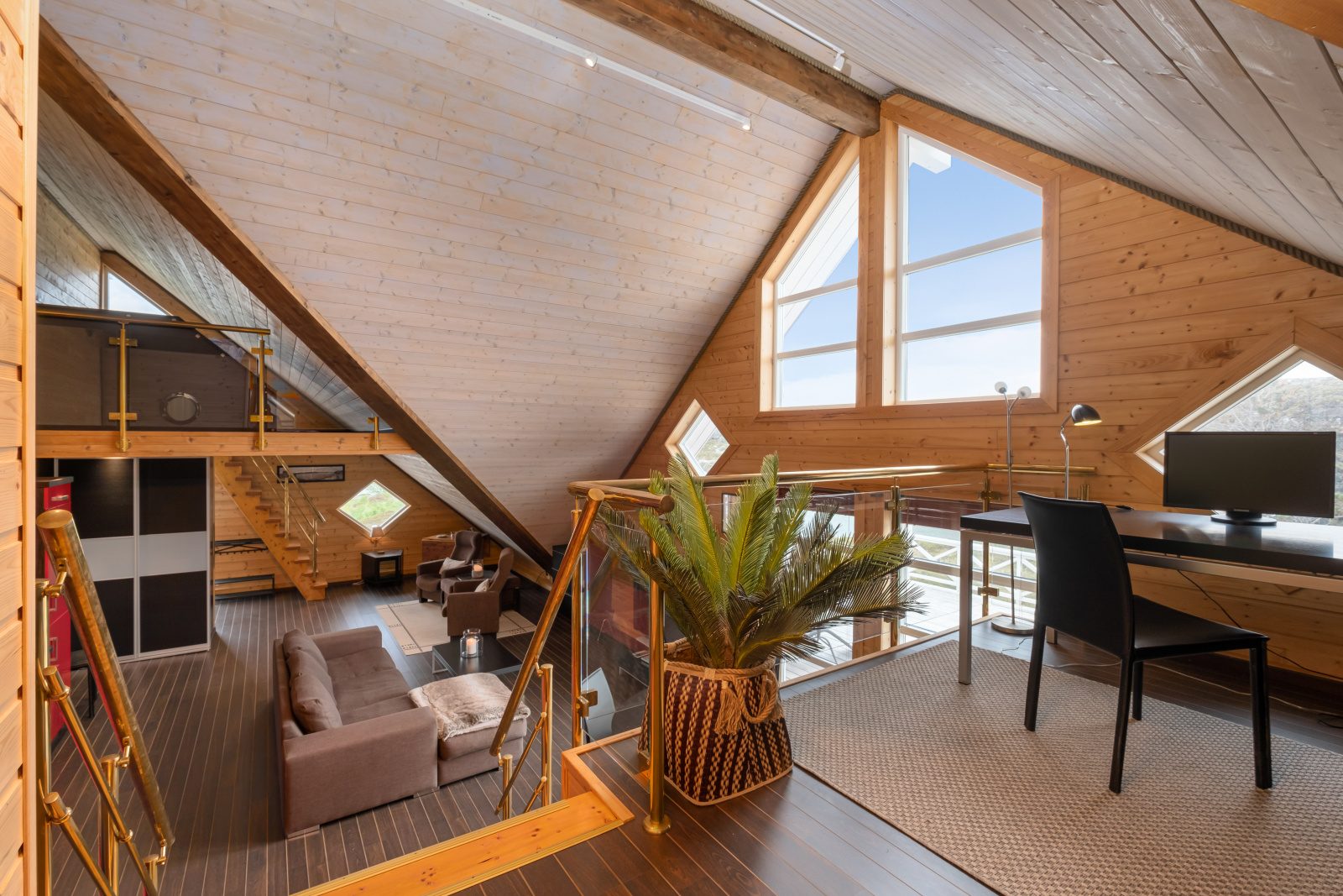 Aurora Suite — mezzanine loft area with brass railings and panoramic windows