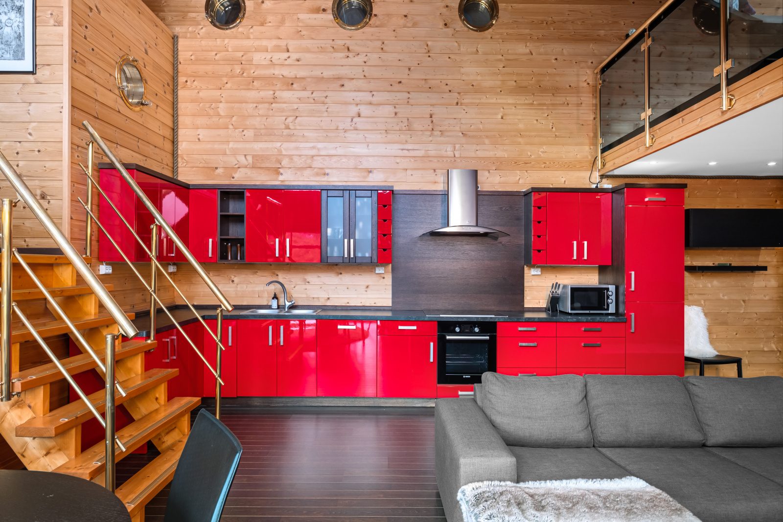 Aurora Suite — red kitchen beneath the mezzanine with porthole windows