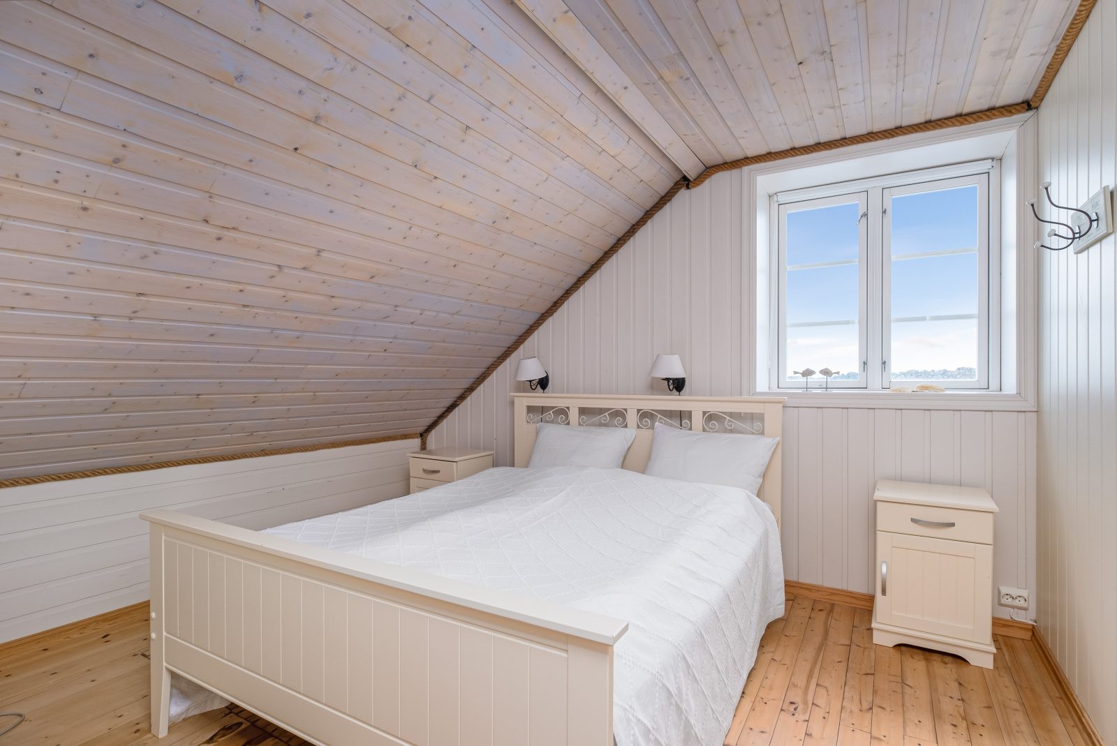 The North Loft — bedroom with white ornate bed and sea view