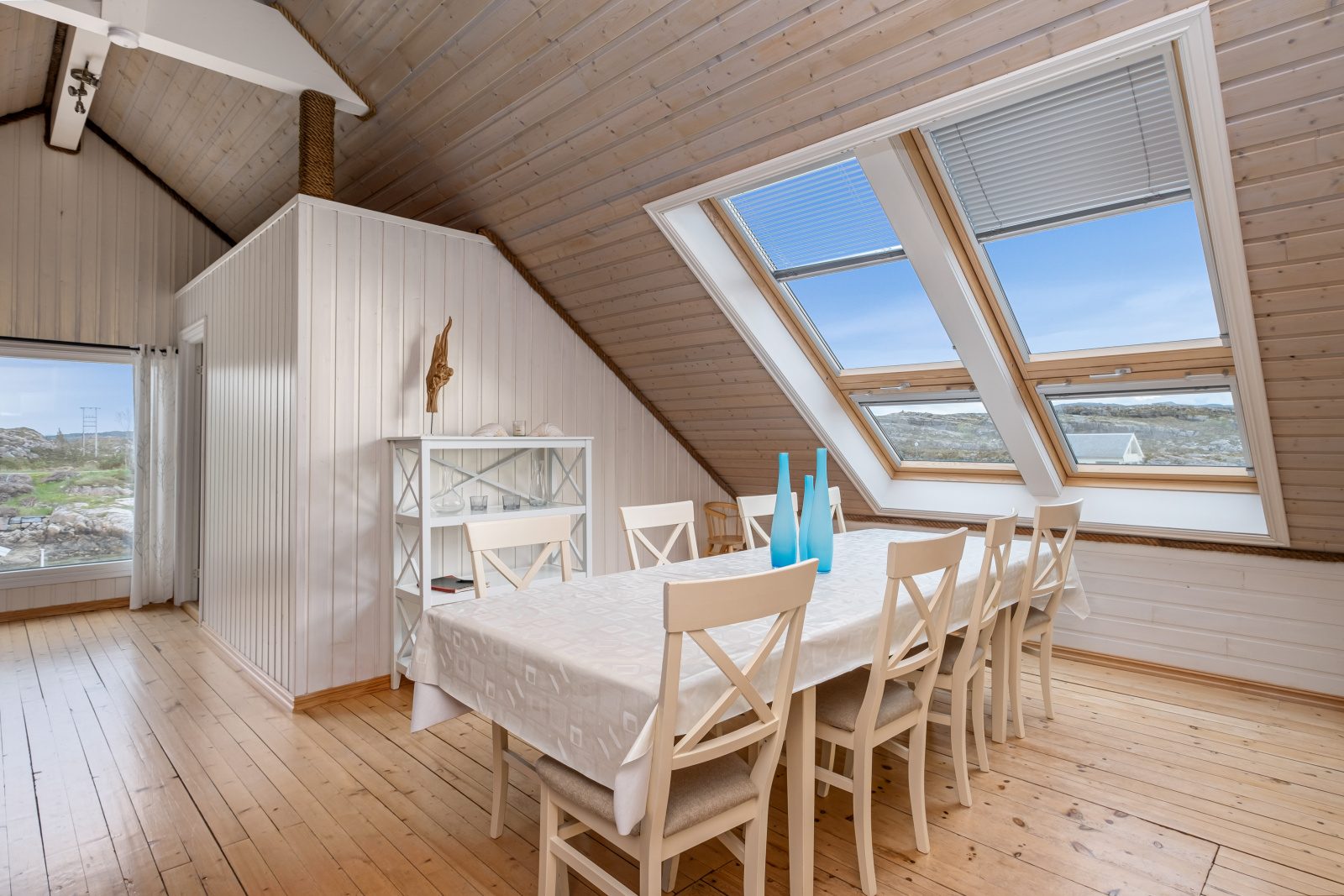 The North Loft — dining room with white table and large roof skylights