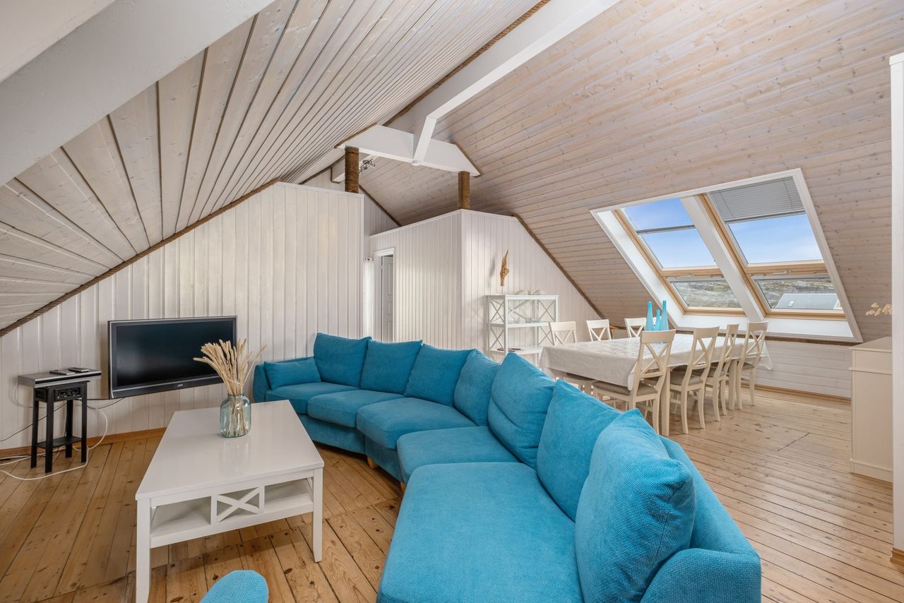 The North Loft — open living and dining with skylights and turquoise sofa
